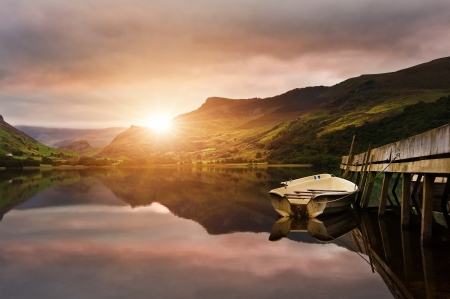 Sunrise over lake with boats moored at jettyの写真素材