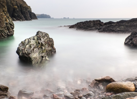 Long exposure flowing tide over and around rocksの写真素材