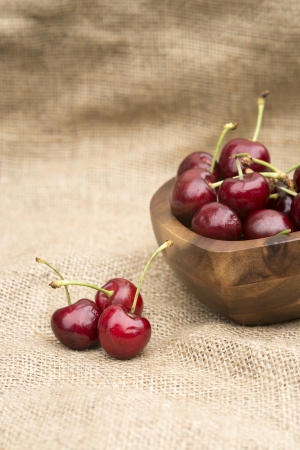 Macro of fresh Summer cherries in wooden bowlの写真素材