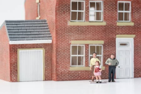 Family home concept with model house and people on white backgroundの写真素材