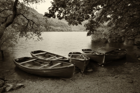Sepia retro style picture of derelict boathouse and rowing boats landscapeの写真素材