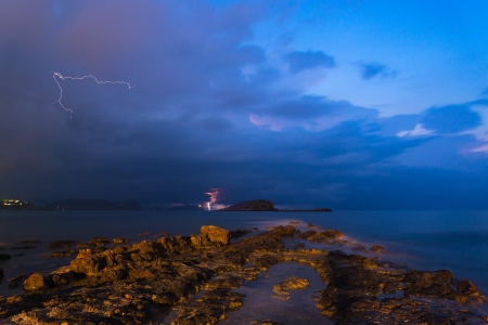 Lightning and storm landscape over beautiful rocky coastline in Mediterranean Seaの写真素材