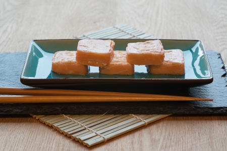 Sushi salmon parcels on dish with chopsticksの写真素材