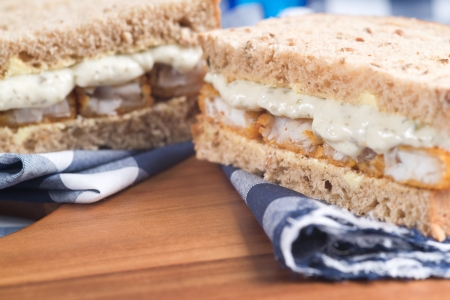 Rustic kitchen setting for fresh fishfinger sandwich on wholegrain