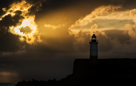 Stunning sunrise over ocean with lighthouse and harbor wallの写真素材