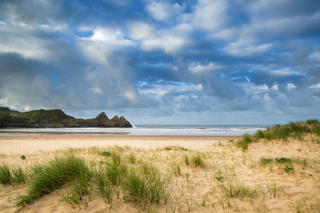 Beautiful morning landscape over sandy beach Three Cliffs Bay