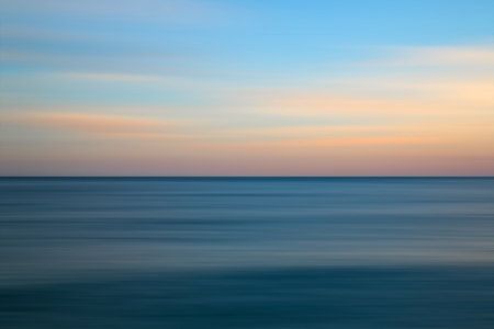 Beautiful long exposure seascape image of calm ocean at sunsetの写真素材
