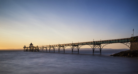 Stunning long exposure sunset over ocean with pier silhouetteの写真素材