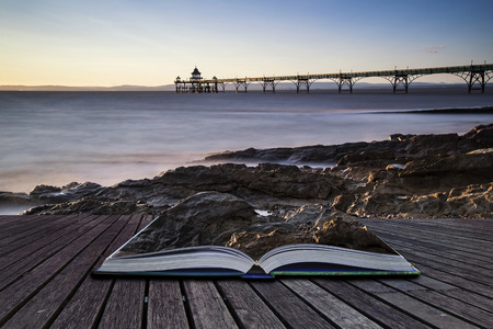 Long exposure landscape image of pier at sunset conceptual book imageの写真素材