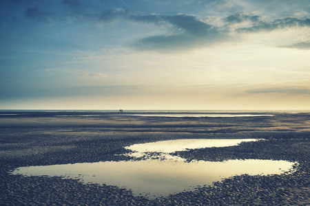 Conceptual landscape image of two people on remote beach の写真素材