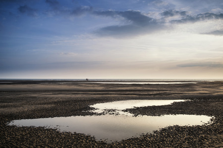 Conceptual landscape image of two people on remote beachの写真素材