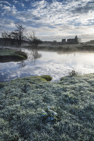 Beautiful dawn landscape of Priory ruins in countryside locationの写真素材