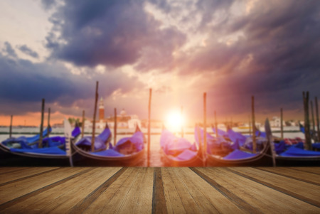 Gondolas atSan Marco Square, Venice Italy with sunburst with wooden planks floorの写真素材