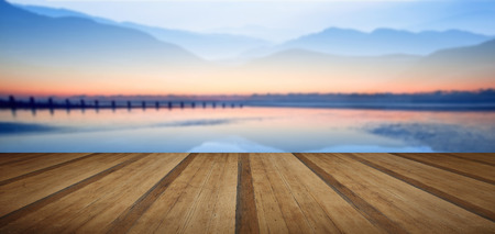 Double exposure effect of mountains and sunrise beach landscape with wooden planks floorの写真素材