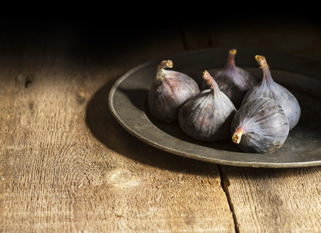 Fresh figs in moody natural lighting set with vintage styleの写真素材