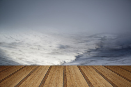 Moody dramatic low cloud Winter landscape in mountains with snow on ground with wooden planks floorの写真素材