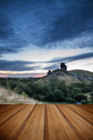Stunning sunrise landscape over ruins of medieval castle with wooden planks floorの写真素材