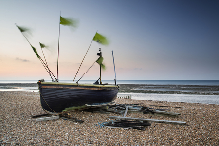 Landscape image of small fishing boats on beach at sunriseの写真素材