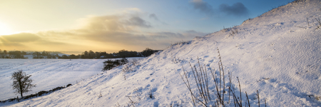 Stunning Winter panorama landscape snow covered countryside with beautiful sky and cloudsの写真素材