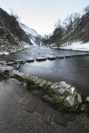 River flowing through snow covered Winter landscape in valley
