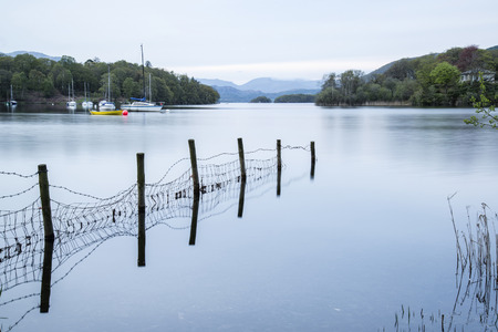 Calm moody evening landscape over Coniston Water in Lake Districtの写真素材