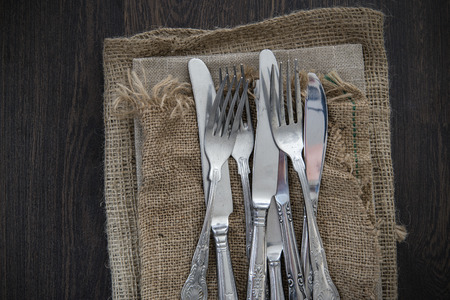 Vintage cutlery on hessian cloths on wooden backgroundの写真素材