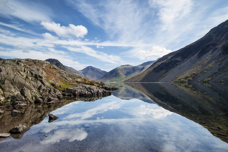 Stunning landscape of Wast Water and Lake District Peaks on Summer day reflected in perfect lake