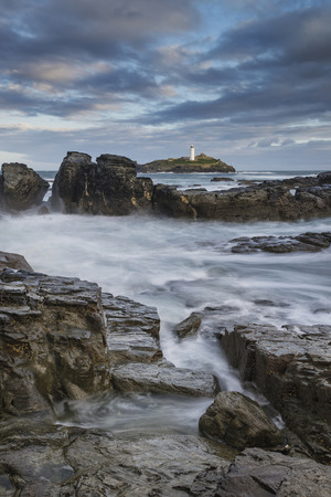 Stunning sunrise landscape image of Godrevy in Corwnall Englandの写真素材