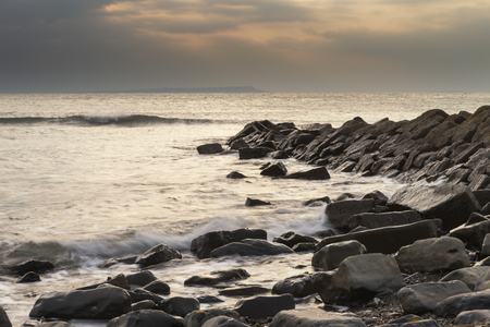 Stunning sunset landscape image of rocky coastline in Dorset Englandの写真素材
