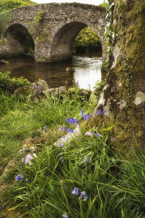 Landscape image of old medieval bridge in river setting in English countryside