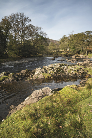 Beautiful Autumn Fall landscape image of river stream in Lake District in Englandの写真素材