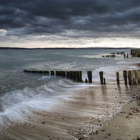 Stormy sky over beach landscape with long exposure and vibrant colorsの写真素材