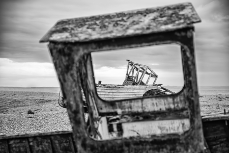 Abandoned derelict fishing boats on shingle beach landscape in Winterの写真素材