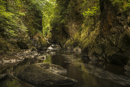 Beautiful panoramic landscape with river flowing through deep sided gorge with vibrant green foliageの写真素材