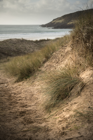 Beautiful landscape image of Freshwater West beach with sand dunes in Pembrokeshire Walesの写真素材