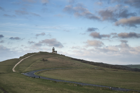 Beautiful landscape image of Belle Tout lighthouse on South Downs National Park during stormy skyの写真素材
