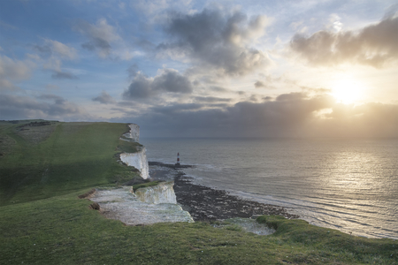 Beautiful landscape image of Beachy Headt lighthouse on South Downs National Park during stormy skyの写真素材
