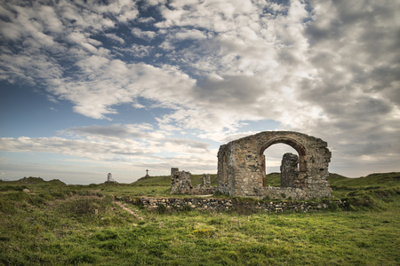 Vew of abandoned 13th Century chapel on Ynys Llanddwyn Island in Angelsey with Twr Mawr Lighthouse in background landscapeの写真素材