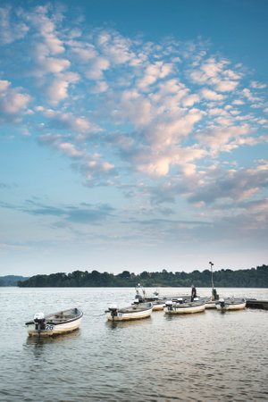 Summer sunset landscape image over calm lake with leisure boats on jettyのeditorial素材