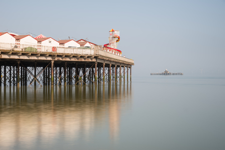 Minimalist fine art image of colorful pier in juxtaposition with old derelict pier in backgroundの写真素材