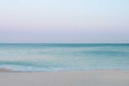 Beautiful sunset landscape image of Porthcurno beach on South Cornwall coast in Englandの写真素材