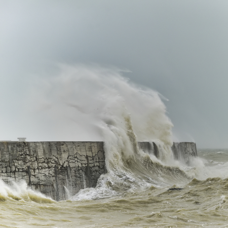 Stunning waves crashing over harbor wall during windy storm at Newhaven on English coastの写真素材