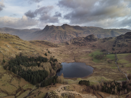 Stunnnig drone aerial sunrise landscape image of Blea Tarn and Langdales Range in UK Lake Districtの写真素材