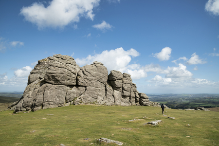 Beautiful Spring landscape image of Haytor in Dartmoor National Park in Devon England on lovely sunny Spring day with unidentified person for scaleの写真素材