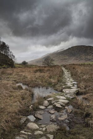 Beautiful Winter landscape image looking along valley from Crimpiau towards Mount Snowdon in the distanceの写真素材