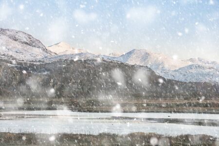 Beautiful Winter landscape image of Mount Snowdon and other peaks in Snowdonia National Park in heavy snow stormの写真素材