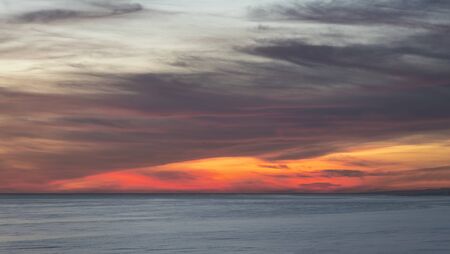 Beautiful Summer landscape sunset image of colorful sky over calm long exposure seaの写真素材