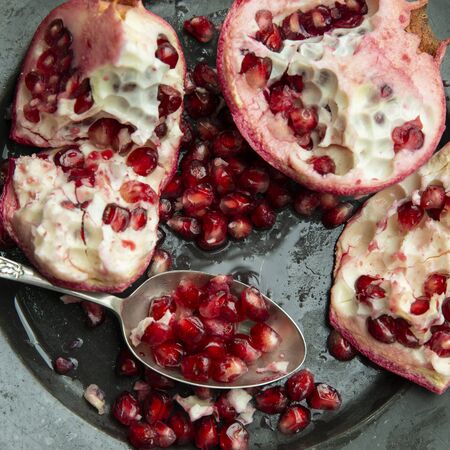 Flat lay image of torn Pomegranate fruit and seeds on textured rough backgroundの写真素材