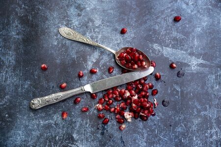 Flat lay image of torn Pomegranate fruit and seeds on textured rough backgroundの写真素材
