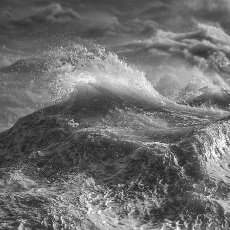 Stunning image of individual wave breaking and cresting during violent windy storm in black and white with superb detailの写真素材